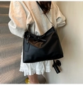 Detail of matte black leather dumpling bag with bow drawstring and adjustable strap - No Pendant / Black