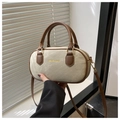 Detail der beigen Canvas-Bowlingtasche mit braunen Ledergriffen und Gold-Schriftzug - Khaki