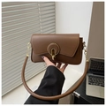 Detail of a brown leather shoulder bag featuring a prominent gold ring metal buckle - Brown