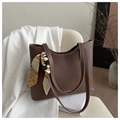 Dettaglio della borsa tote in pelle marrone scuro con foulard di seta su una sedia - Marrone Scuro