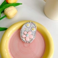 Detail der glitzernden Tulpen-Handyhalterung auf einem pastellfarbenen Keramiktablett - Ovale Gänseblümchenblume