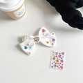 Detail der weißen Satin-Bogen Handyhalterung mit bunten Strasssteinen und DIY-Stickern - Weißer Satinknoten + Strasssteine