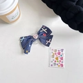Detail der Handyhalterung aus blauem Denim mit rosa Herz-Strass und DIY-Stickern - Denim Blauer Knoten + Strasssteine