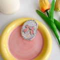 Detail eines pinkfarbenen Glitzer-Bogen-Handyhalters mit Herz-Pailletten-Dekor - Oval Rosa Schleife