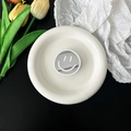 Detail van een draagbare smiley spiegel telefoonhouder op een wit keramisch dienblad - Wit