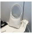 Detail of white woven texture on a minimalist hobo bag styled on a white blazer - White