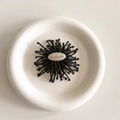 Detailed top view of handmade black beaded flower phone grip with silver logo plate - Black