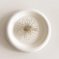 Macro view of a silver floral phone grip with a handmade engraved oval metal badge - White