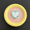 Detail of a minimalist MagSafe phone grip featuring a heart design with a gift card - Light Green