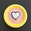 Macro shot of purple heart-shaped MagSafe phone grip with white center on gift card - Deep purple