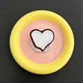Close-up of heart-shaped magnetic phone grip and mirror on colorful ceramic tray - Brown