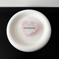 Makro-Detail einer herzförmigen rosa Glitzer-Handyhalterung mit integriertem Schminkspiegel - Transparente Halterung-Hochglanz-Herzspiegel-Rosa