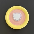 Macro detail of heart-shaped MagSafe phone stand with glitter and vanity mirror on ceramic tray - Purple