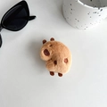 Detailed view of Capybara plush phone grip on desk with sunglasses and ceramic cup - Plush Side-view Capybara (Light Brown)