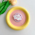 Macro shot of cloud-shaped mirror phone grip on yellow and pink minimalist tray - Pink
