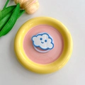 Detail of cloud-shaped makeup mirror phone grip on a yellow ceramic tray with tulips - Blue