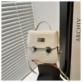 Detail of cream leather shoulder bag featuring dual metallic buckles and top handle - White
