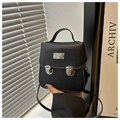 Macro view of black crossbody bag with silver buckle closures and matte leather texture - Black