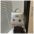 Detailed view of a metallic silver mini bag featuring dual metal locks and brand plaque - Silver