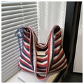 Detail der rot-blau gestreiften Canvas-Tasche mit blauer Spitze und Kunstleder-Patch - Grün