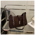 Détail du sac à main marron foncé motif crocodile avec chaîne argentée et fermoir rotatif - café