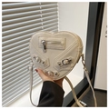 Dettaglio della borsa a forma di cuore con borchie argento punk e cerniere metalliche - Bianco