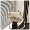 Detail of cream white faux leather handbag featuring a vintage gold oval metal buckle closure - White