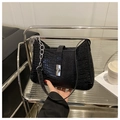Detailed close-up of a black crocodile-patterned tote bag featuring a silver twist-lock - Black