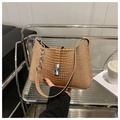 Détail d'un sac à main kaki motif crocodile avec chaîne argentée et fermoir rotatif - Kaki