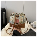 Primer plano del bolso saco étnico con brocado floral y detalles de cuero marrón - Marrón