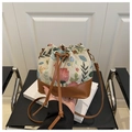 Detailed view of floral tapestry texture and brown leather drawstring on the bucket bag - Brown