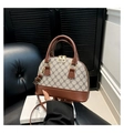 Detail of shell-shaped bag with classic monogram leather and gold zipper hardware - Coffee