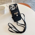 Detail of black quilted iPhone case with gold bow, pearls, and crossbody strap - iPhone 7/8/SE 2020 / Black