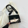 Bolso bandolera moderno en blanco y negro con herrajes dorados y correa ancha de flechas - Negro