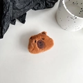 Close-up of a soft brown plush bear phone socket with detailed embroidery on white background - Deep Brown Capybara Head (Black Grip)