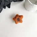 Detail of plush star-shaped phone socket featuring a cute embroidered animal face - Deep Brown Capybara Star Shape (Black Grip)