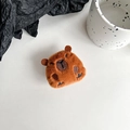 Macro detail of plush Capybara phone socket with soft brown texture and embroidery - Deep Brown Capybara Full Body Front (Black Grip)