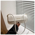 Detailed close-up of white rectangular shoulder bag featuring gold fashion typography - White
