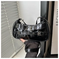 Detail of black glossy shoulder bag featuring punk style metal eyelets and belt buckle straps - Black