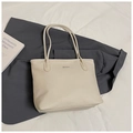 Detalle de bolso tote en cuero granulado blanco roto con placa de logo plateada - Blanco