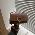 Brown woven texture baguette bag with golden horseshoe buckle and braided shoulder strap - Tan