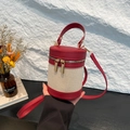 Bolso de hombro cilíndrico en contraste de color rojo y beige con detalles de lona y piel - Rojo