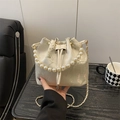 Elegante cremefarbene Beuteltasche mit Perlengriff und Stickerei im Lifestyle-Ambiente - Weiß