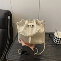 Off-white bucket bag with floral embroidery, pearl handle, and golden chain strap - White