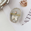 Detail eines ovalen Handyhalters mit rosa Blume, weißer Schleife und Good Luck Text - Rosa Tulpen Fliege