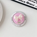 Macro view of a pink magnetic phone socket with a 3D pearlescent white bow and gift icons - Pink