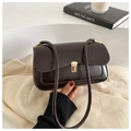 Vintage dark brown matte leather baguette bag with gold buckle on a beige background - Coffee