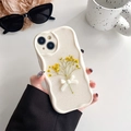 Close-up of wavy cream iPhone case with dried yellow flowers and 3D white bow tie detail - Cream Glitter Dried Flowers - Yellow / iPhone 7/8/SE 2020