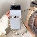 Detailansicht der Galaxy Z Flip Hülle mit silberner Schleife und klobigem Perlenketten-Griff - Silber Dreiteiliges Set - Strass Herz Schleife - Silberne Perlenkette / Samsung ZFlip3