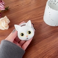 Primer plano del soporte para móvil de gato blanco con grabado sobre mesa de madera - Blanco (Ojos Amarillos)